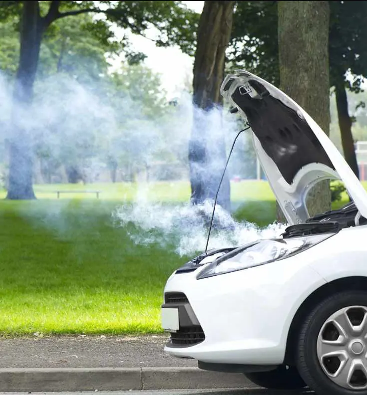 A broken-down car with smoke pouring from under its open bonnet