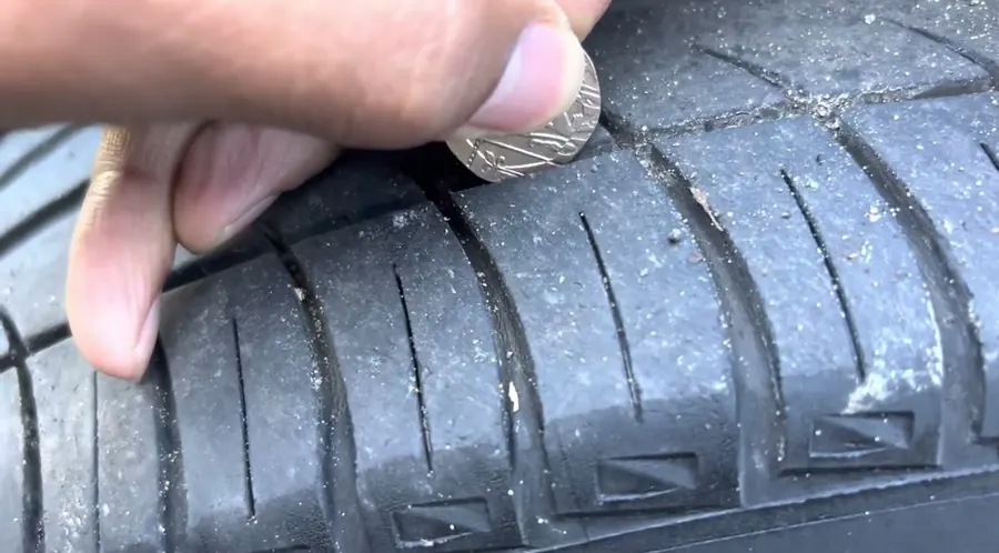 A 20p coin pushed into a tyre’s tread groove